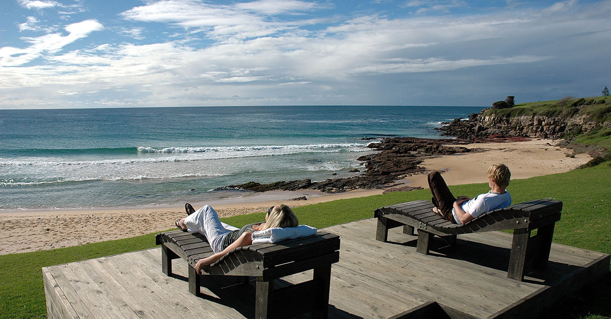 Two people relaxing on chairs on the headland at Bermagui.