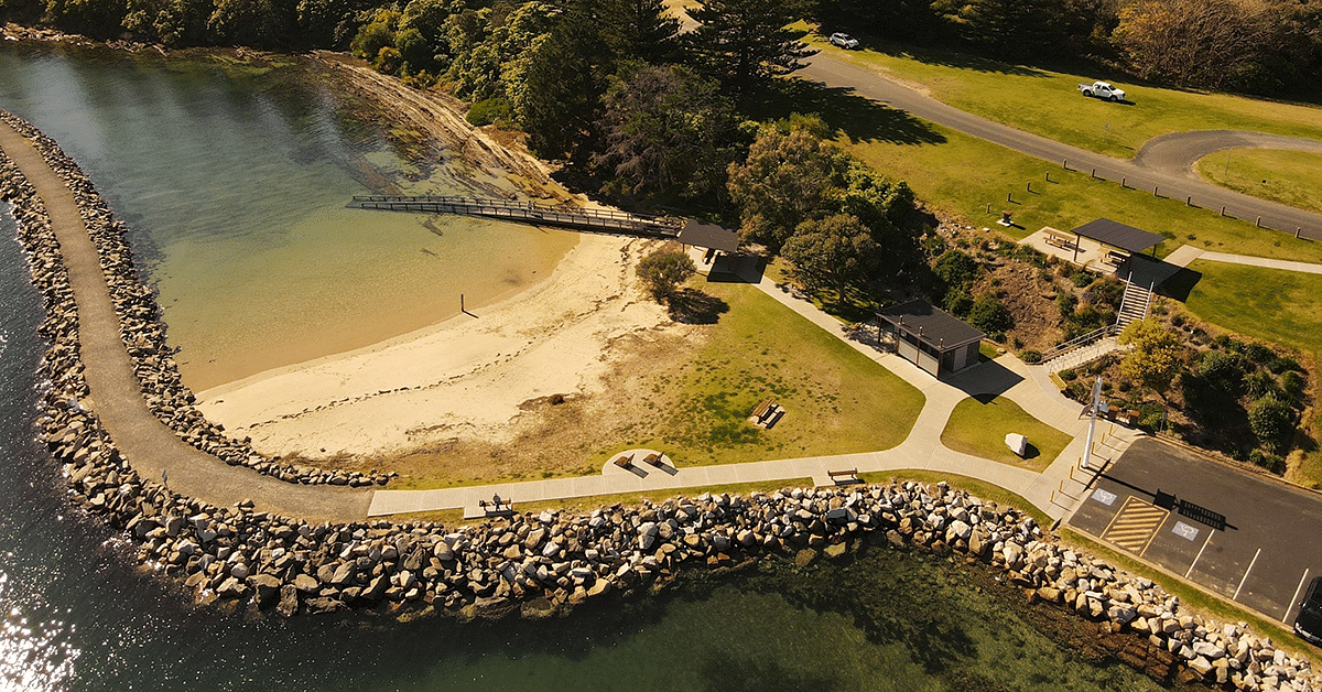 an aerial view of Bruce Steer Pool in Bermagui. Photo shows a calm ocean swimming pool and rock wall