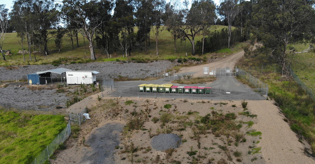 Cobargo tip site with fence around it and bin banks.