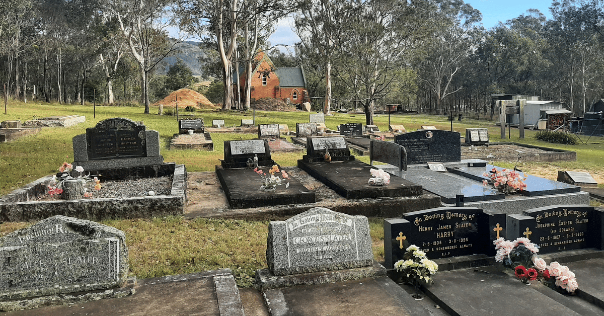 Tantawangalo cemetery, with graves in the foreground and a small rural church in the background.
