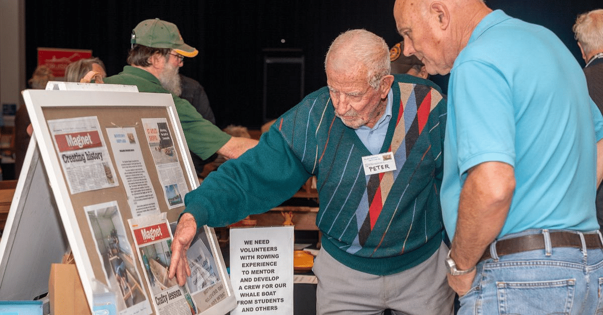a man showing another man a poster that talks about volunteer opportunities.