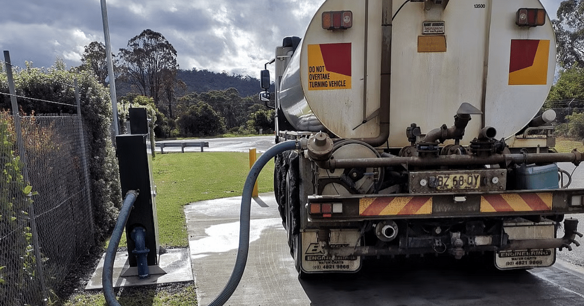 photo of a man filling a truck with water.
