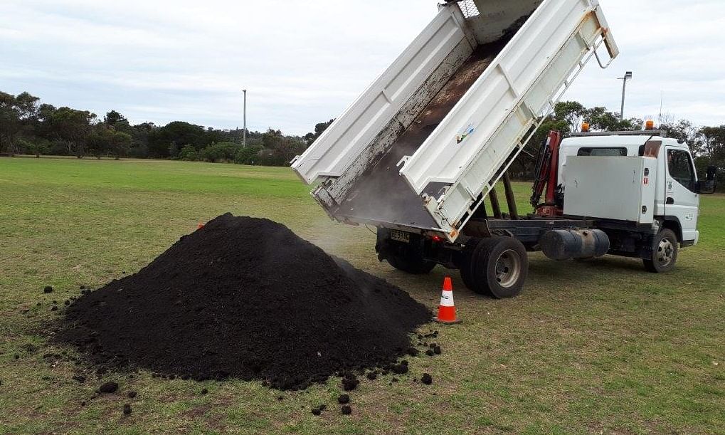 Waste truck emptying compost.