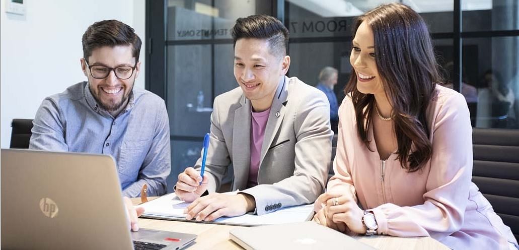 Business people at a desk in front of a computer.