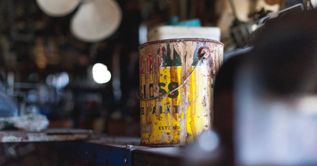 An old paint can on a work bench in a shed