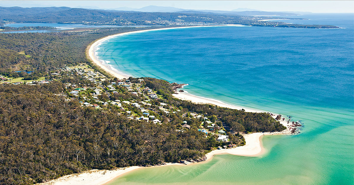 Aerial view of the Pambula rivermouth beach, Lions Park beach, and Pambula Beach, with Merimbula in the background