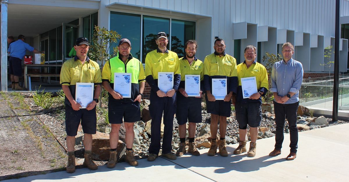 The six Water and Sewerage Services graduates stood side-by-side holding their certificates