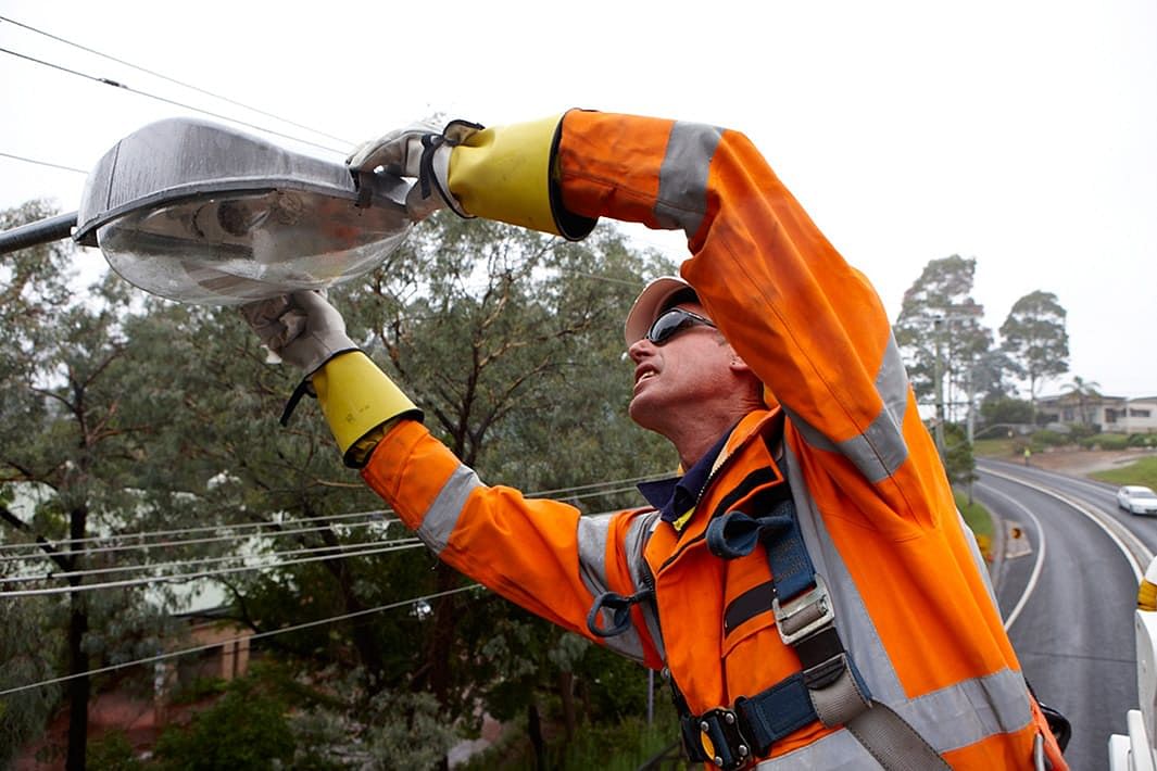 Essential energy working fixing a street light.